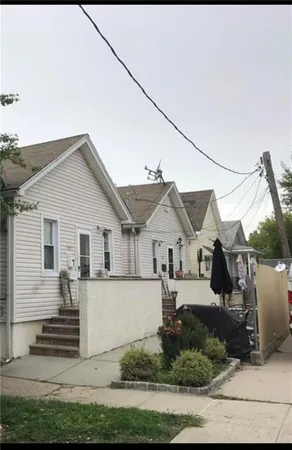 a view of a white house next to a yard
