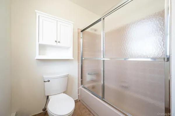 a white toilet sitting next to a shower