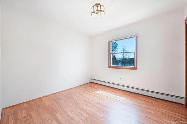 an empty room with a wooden floor and a window