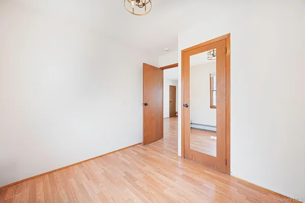 a view of an empty room with closet and a window