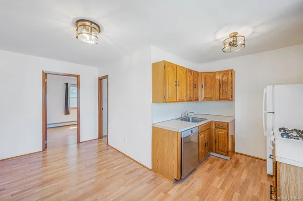 a kitchen with stainless steel appliances granite countertop a stove a sink and a refrigerator with wooden floors