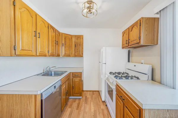 a kitchen with stainless steel appliances granite countertop a sink a stove and a refrigerator