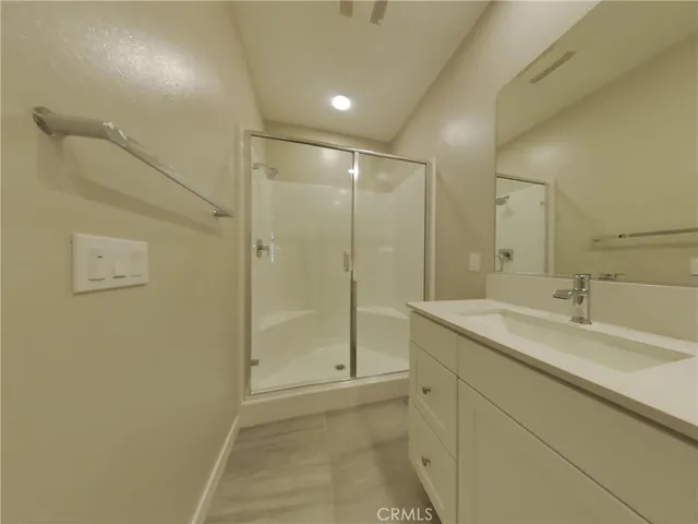 a bathroom with a shower sink vanity and mirror