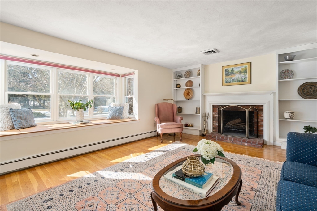 115 Victoria Road Sudbury, MA 01776 - Photo 7 of 41 a living room with furniture a large window and a fireplace