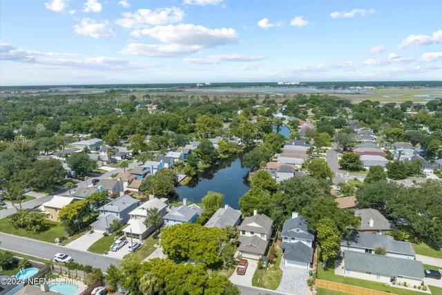 an aerial view of residential houses with outdoor space and trees