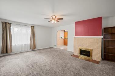 129 Sunset Boulevard Hermitage, PA 16148 - Photo 12 of 34 an empty room with windows fireplace and a kitchen view