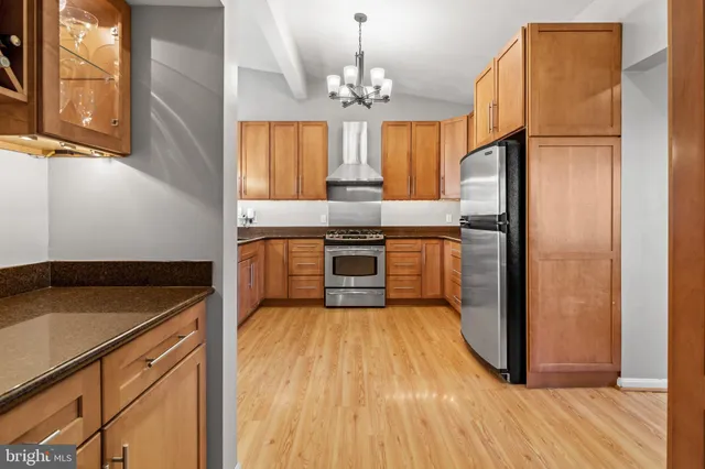 a kitchen with granite countertop stainless steel appliances a stove top oven a sink and cabinets