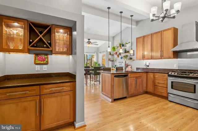 a kitchen with stainless steel appliances granite countertop a sink cabinets and wooden floor