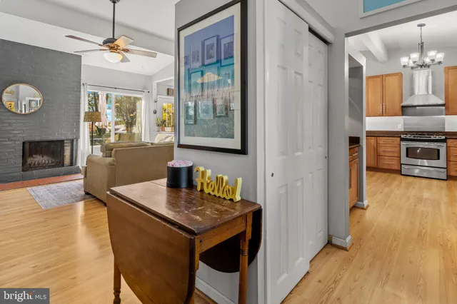 a kitchen with granite countertop a stove top oven a sink dishwasher and a fireplace with wooden floor