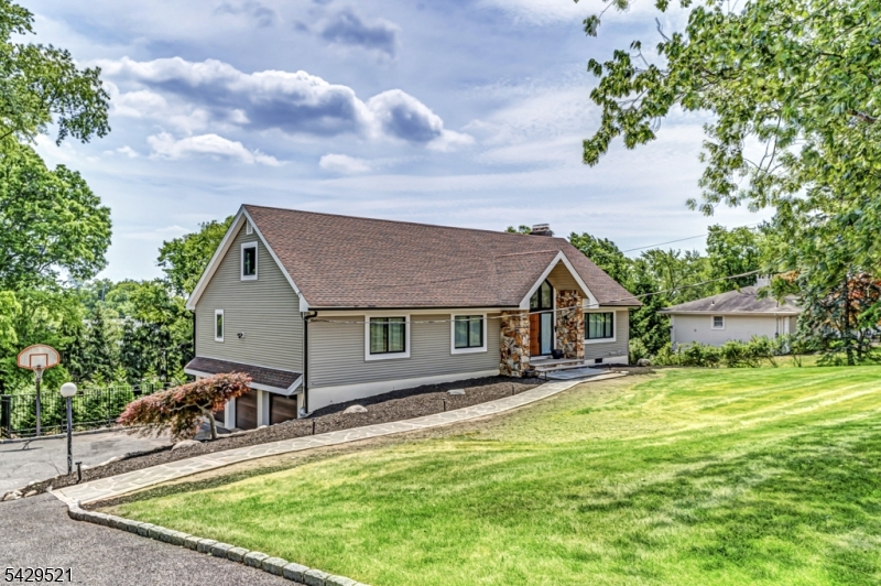a view of a house with a big yard and large trees