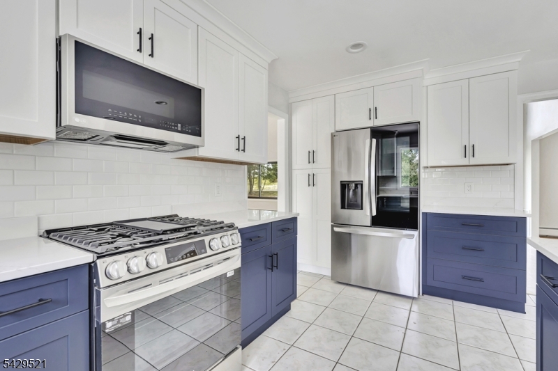 136 Carlough Road Upper Saddle River, NJ 07458 - Photo 13 of 32 a kitchen with stainless steel appliances granite countertop a stove a microwave and a refrigerator