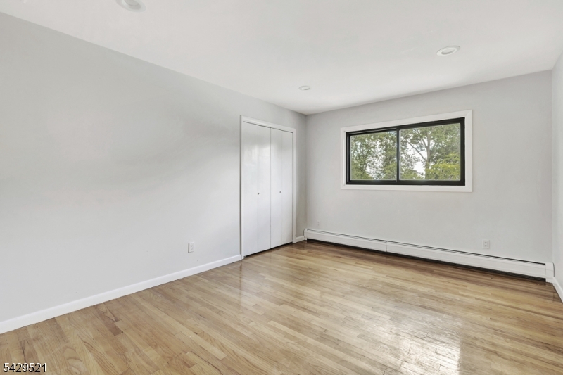 136 Carlough Road Upper Saddle River, NJ 07458 - Photo 21 of 32 an empty room with wooden floor and windows