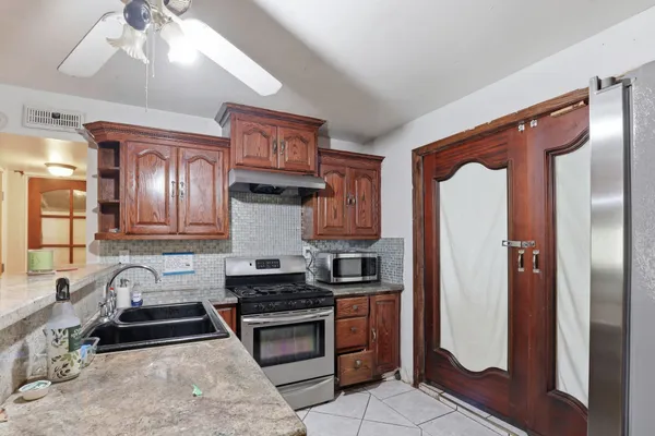 a kitchen with stainless steel appliances granite countertop a refrigerator and a sink