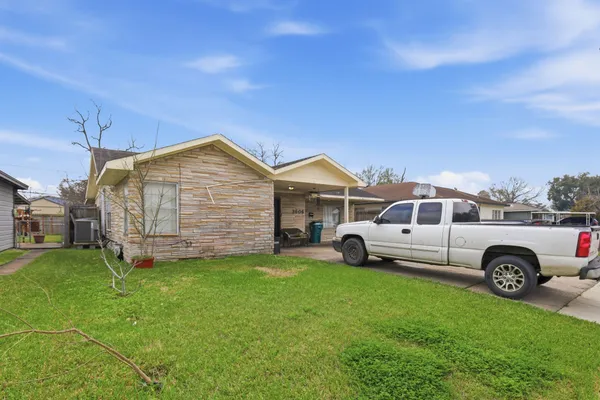 a front view of a house with a garden and parking space