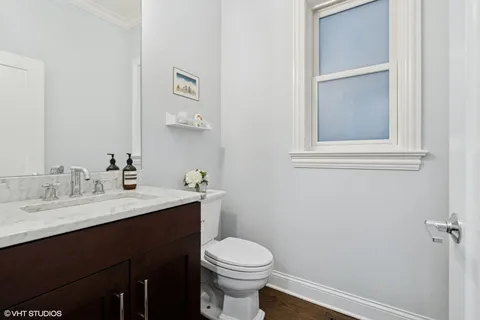 a bathroom with a sink vanity mirror and toilet