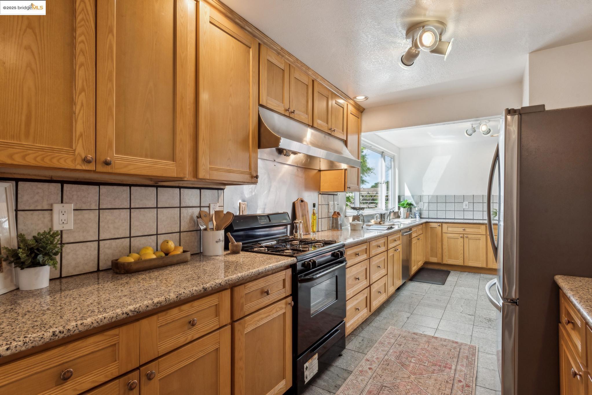 Undisclosed Address San Leandro, CA 94577 - Photo 18 of 50 a kitchen with stainless steel appliances granite countertop a sink a stove and a refrigerator