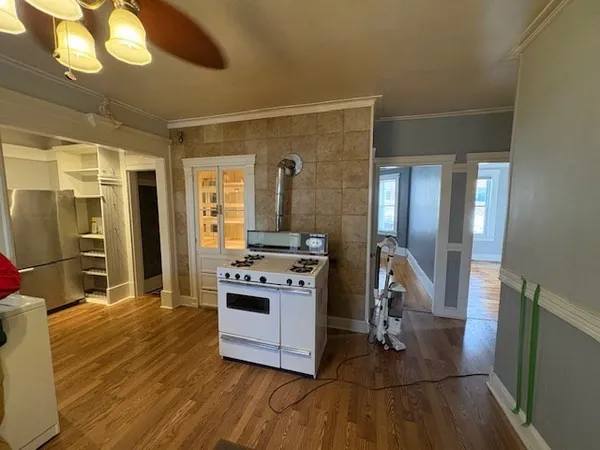 a kitchen with stainless steel appliances granite countertop a stove and a wooden floors