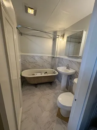 a bathroom with a sink a toilet and shower