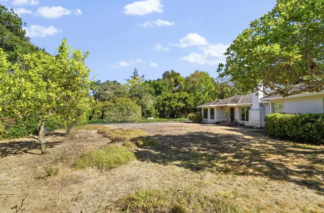 a front view of a house with a yard and trees