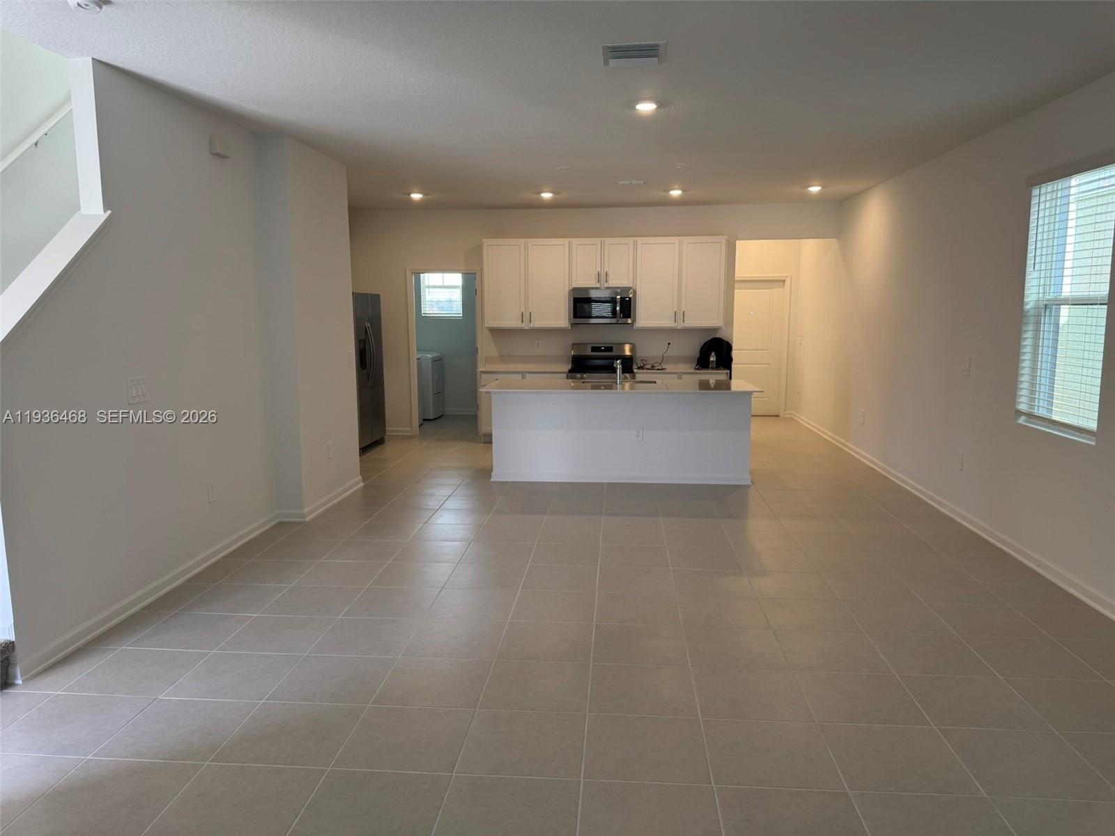 2517 Spring Tune Alley Kissimmee, FL 34744 - Photo 6 of 16 a view of living room with kitchen island furniture and a window
