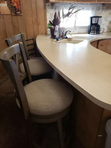 a view of a kitchen with granite countertop a sink dishwasher stove and refrigerator with wooden floor