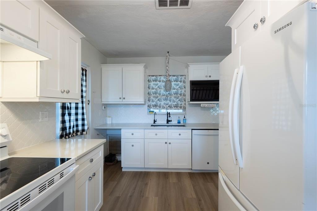 314 4th Avenue Southwest Ruskin, FL 33570 - Photo 12 of 30 a kitchen with granite countertop white cabinets and white appliances