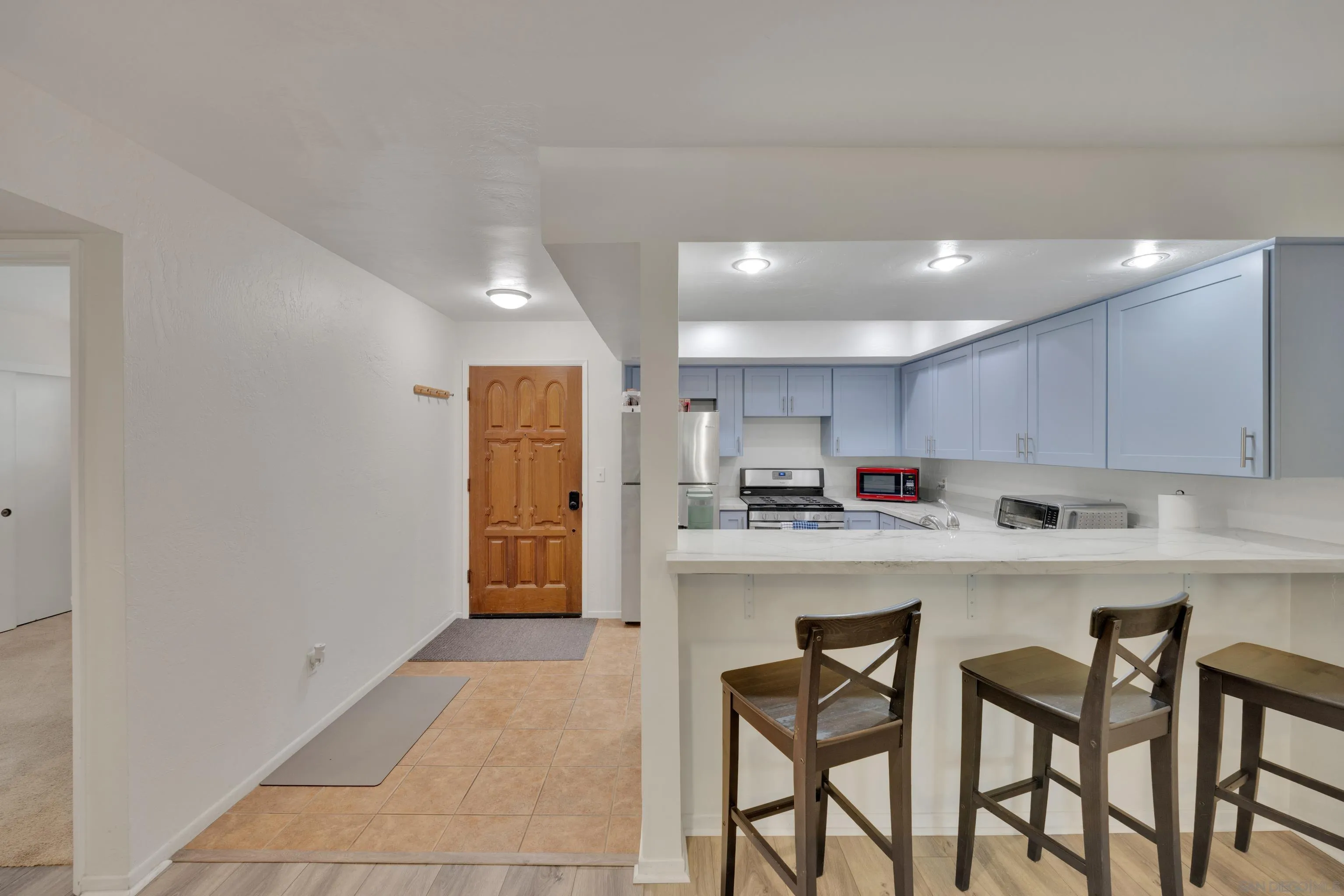 4055 Falcon Street, Unit 102 San Diego, CA 92103 - Photo 4 of 36 a kitchen with refrigerator and chairs