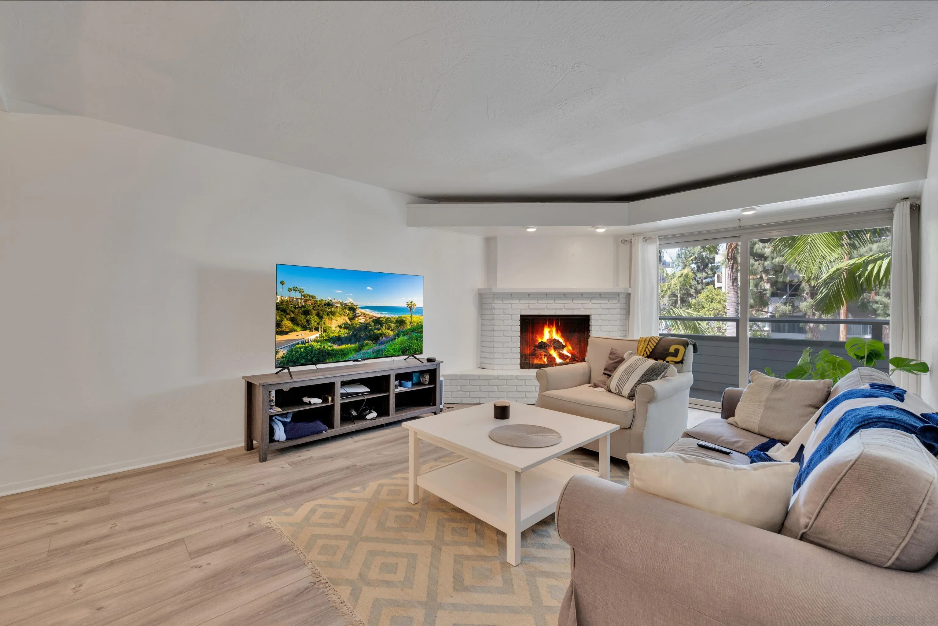 4055 Falcon Street, Unit 102 San Diego, CA 92103 - Photo 10 of 36 a living room with furniture a flat screen tv and a floor to ceiling window