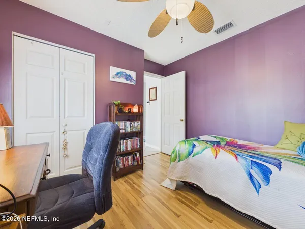 a bedroom with a bed a dresser and chair