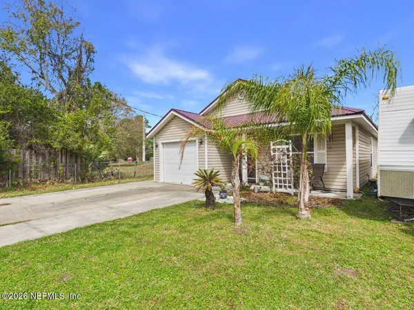 a view of a house with backyard and a tree