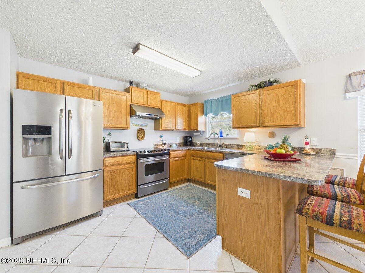 1240 4 Mile Road St. Augustine, FL 32084 - Photo 6 of 27 a kitchen with granite countertop a refrigerator stove top oven and sink