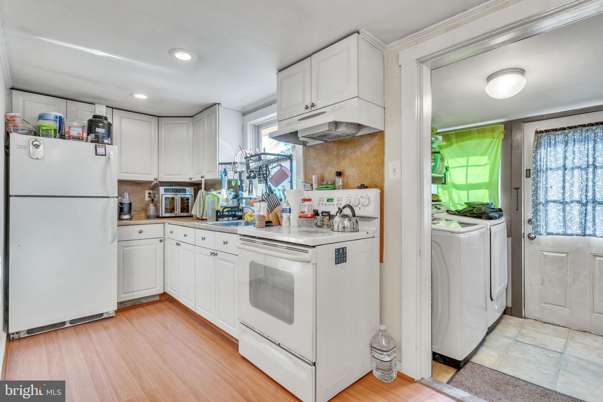 4871 Avery Road Shady Side, MD 20764 - Photo 11 of 20 a kitchen with kitchen island white cabinets and white appliances