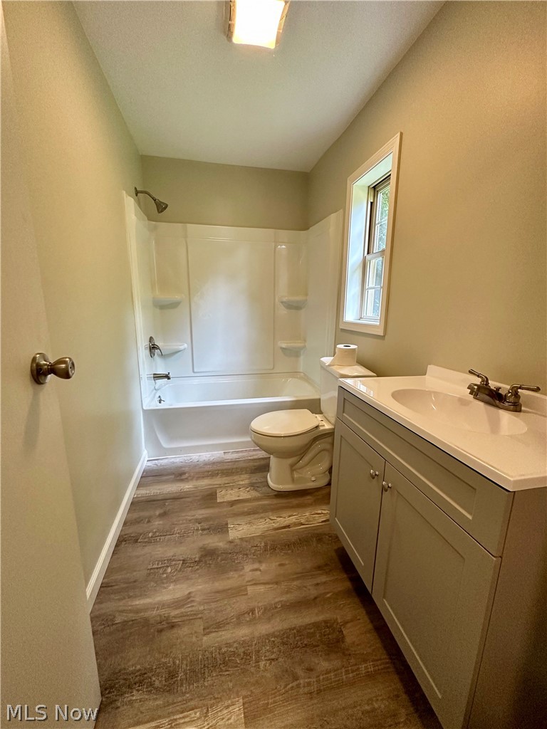 48963 Bloomfield Road East Liverpool, OH 43920 - Photo 9 of 25 Full bathroom featuring shower / bathing tub combination, wood-type flooring, vanity, and toilet
