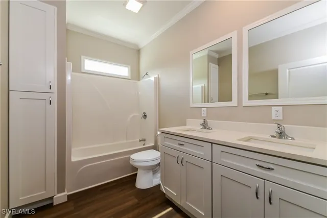 a bathroom with a granite countertop toilet a sink and a mirror