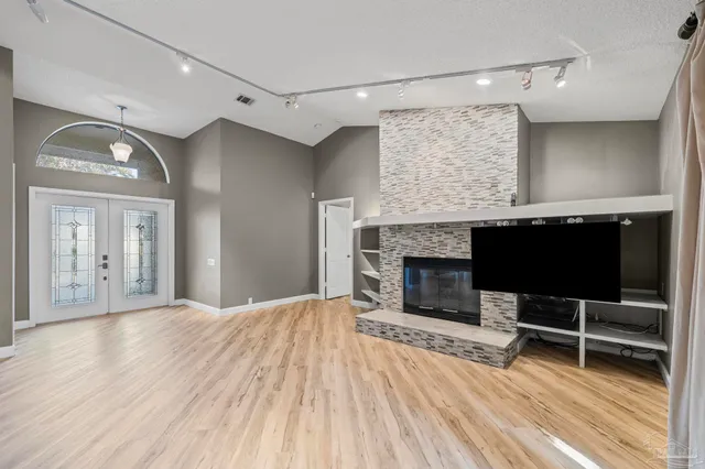 a view of a livingroom with wooden floor and a fireplace
