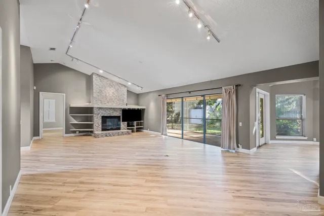 a view of a livingroom with a fireplace wooden floor and window