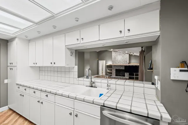 a kitchen with granite countertop a sink and white cabinets