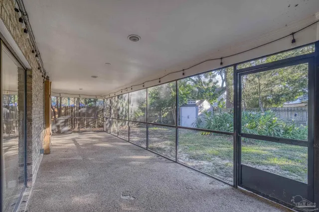 a view of a backyard with large trees and wooden fence