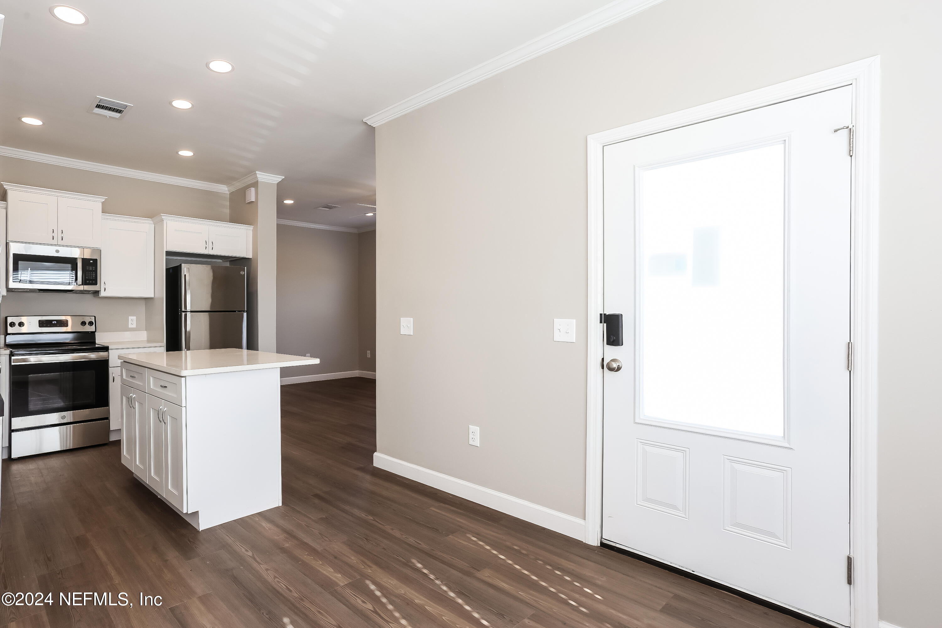 2119 Lewis Street Jacksonville, FL 32204 - Photo 4 of 14 a kitchen with a refrigerator and white cabinets