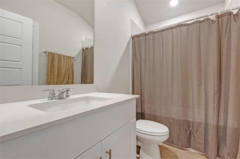 2643 Homestead Rnch Lane Crosby, TX 77532 - Photo 14 of 23 a bathroom with a sink a toilet a mirror and shower curtain