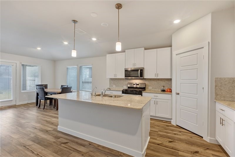 2643 Homestead Rnch Lane Crosby, TX 77532 - Photo 6 of 23 a kitchen with stainless steel appliances kitchen island granite countertop a stove a sink a refrigerator and white cabinets with wooden floor