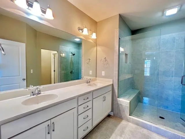 a bathroom with a double vanity sink mirror double and shower