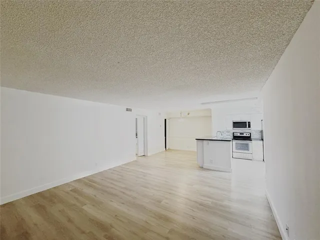 a view of a kitchen with a sink and a refrigerator