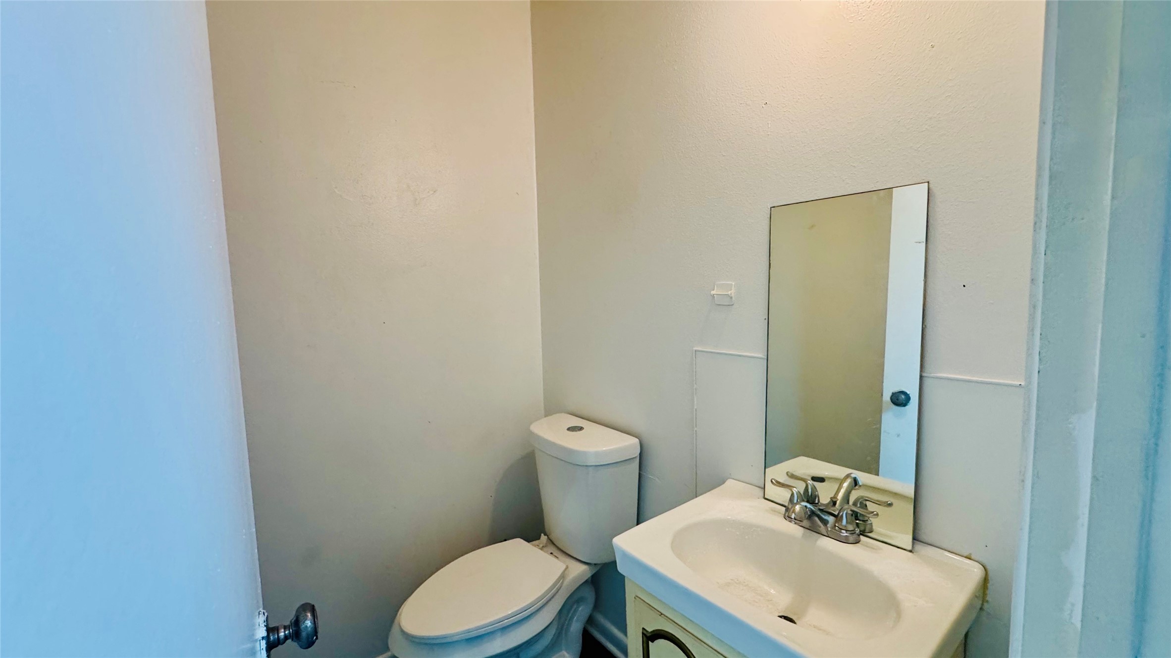 811 North Travis Street Liberty, TX 77575 - Photo 19 of 31 a bathroom with a toilet a sink and mirror