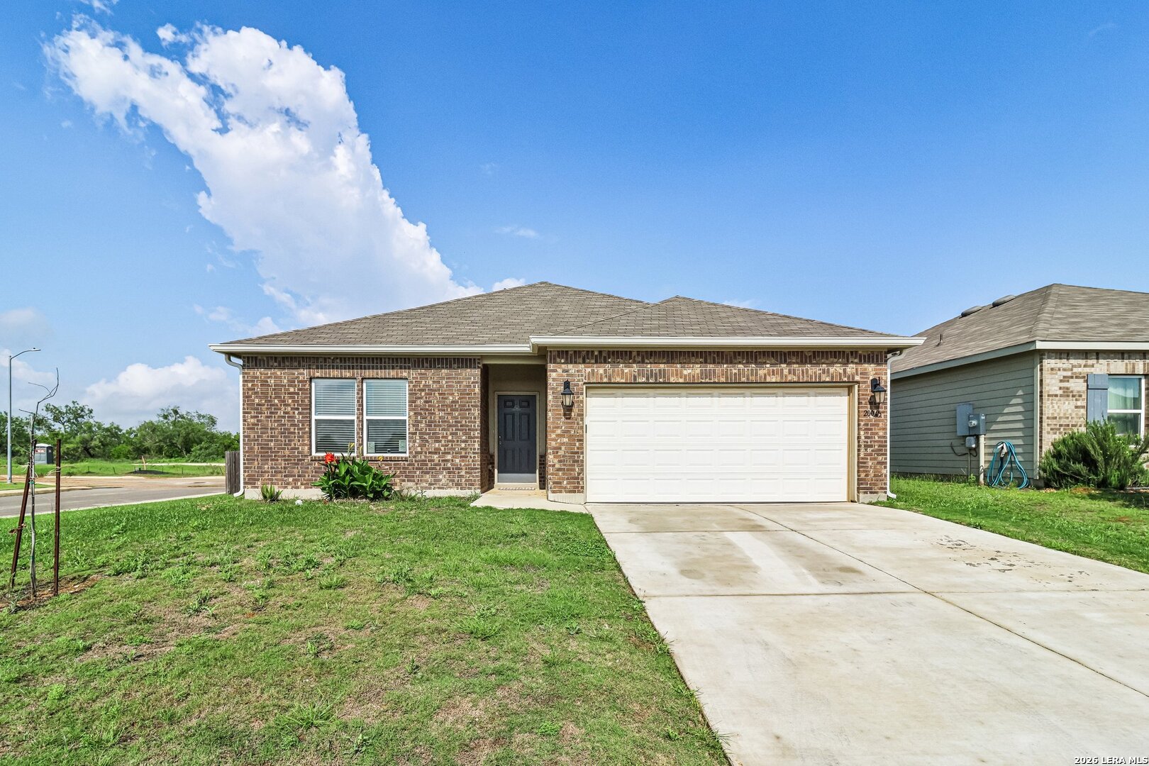 20045 Huckleberry Street Lytle, TX 78052 - Photo 1 of 39 a front view of a house with a garden and yard
