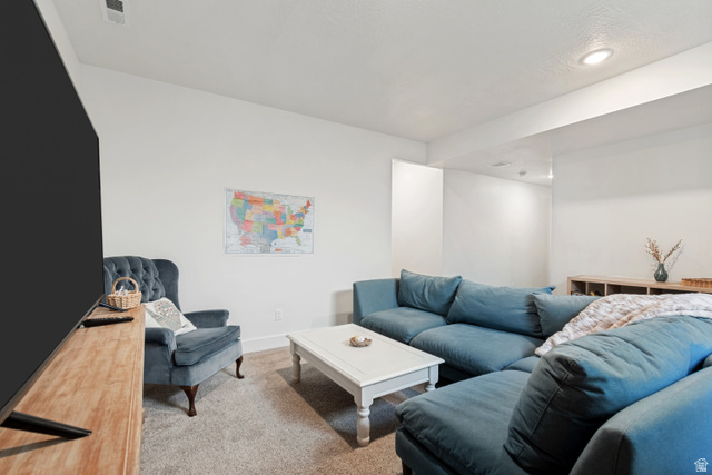 683 Kings Landing Tooele, UT 84074 - Photo 23 of 39 Spacious living area featuring neutral wall tones and a textured carpet