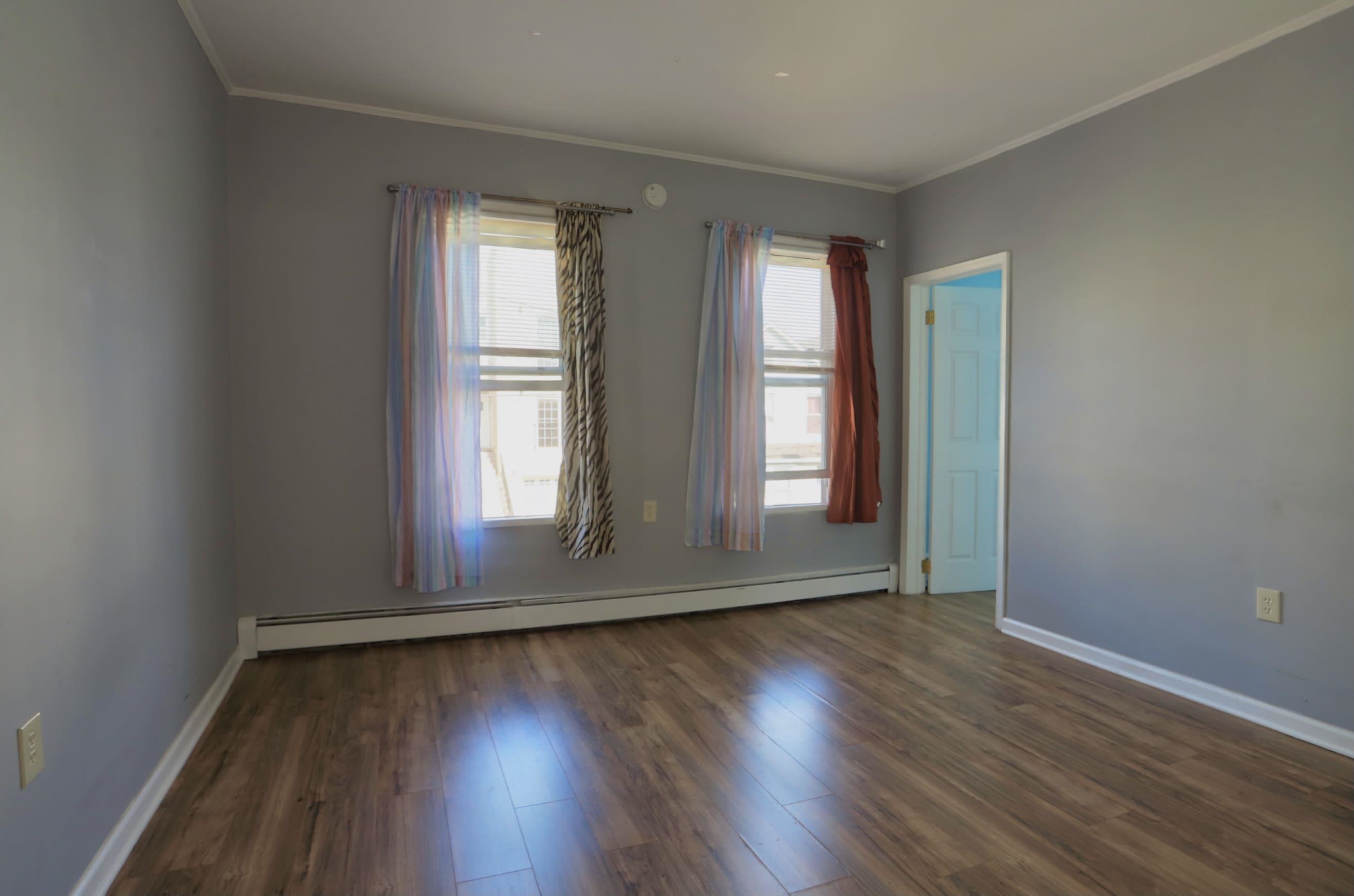 17 Grant Avenue, Unit 2 Harrison, NJ 07029 - Photo 11 of 17 an empty room with wooden floor and windows