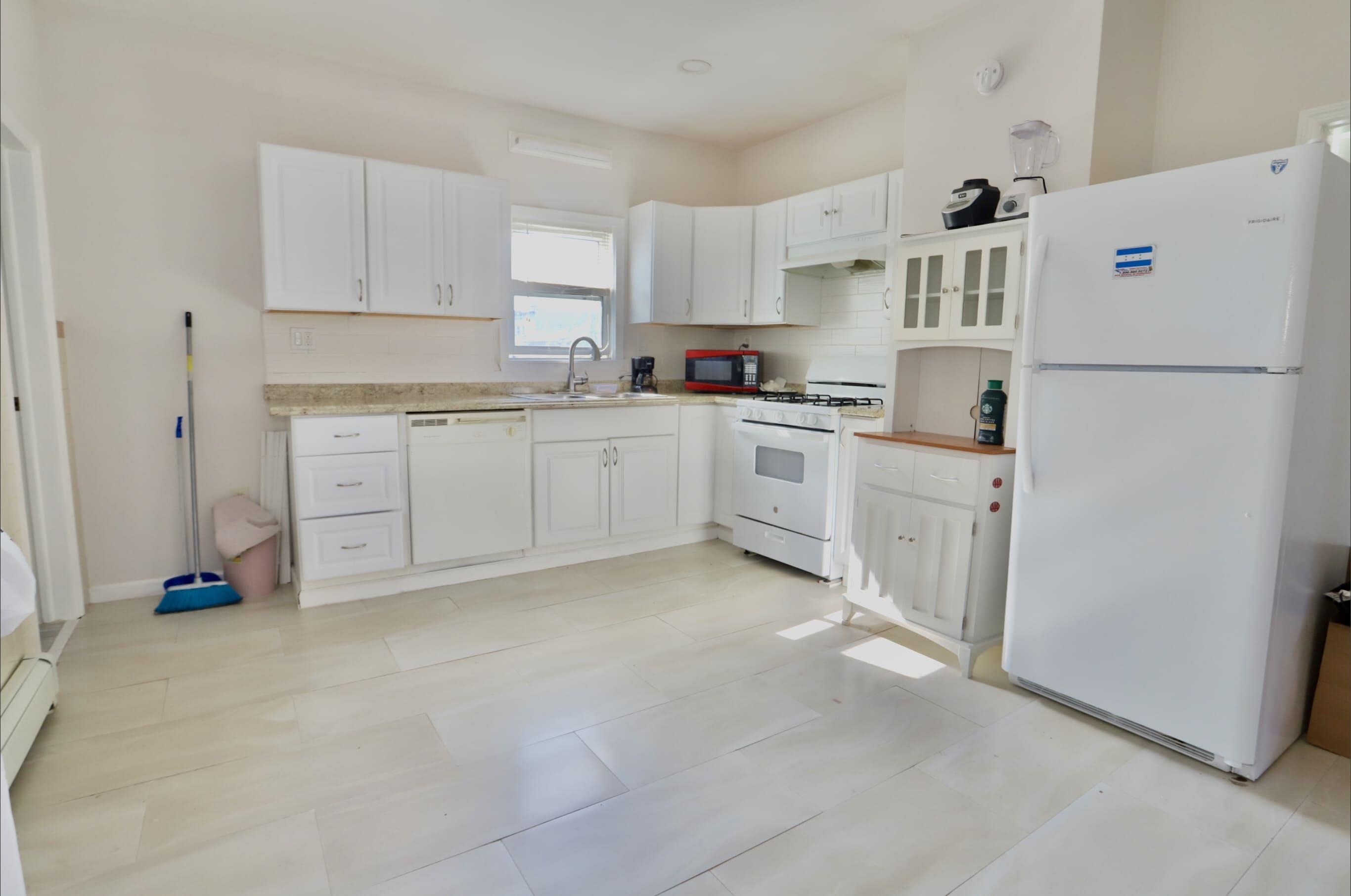 17 Grant Avenue, Unit 2 Harrison, NJ 07029 - Photo 3 of 17 a kitchen with white cabinets and white appliances