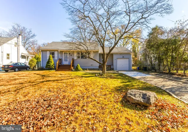 a view of a house with a yard covered with snow and trees