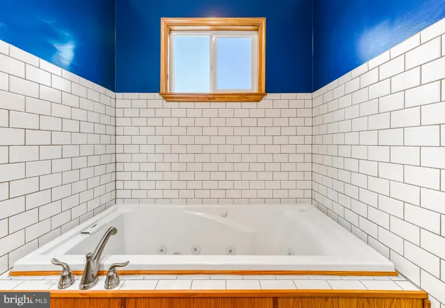 a bathroom with a bathtub and next to a window